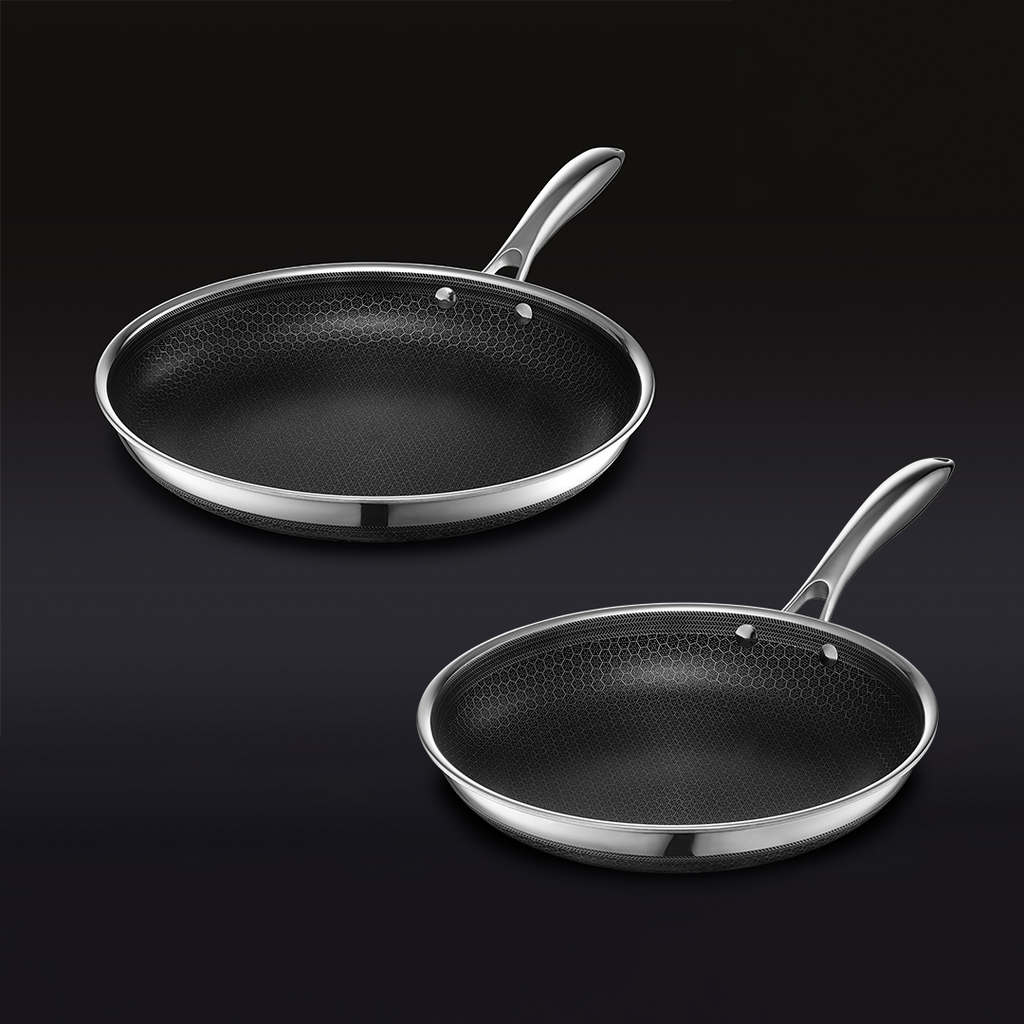 A nonstick frying pan and saucepan with a lid, featuring a hexagonal-patterned interior, on a black background.
